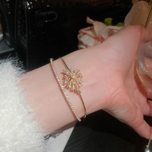 Detail of elegant gold double-layered bracelet with zircon fireworks and pearl on model