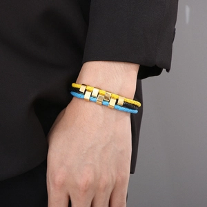 Detail of woven leather bracelet set in black blue and yellow with metal alloy clasps
