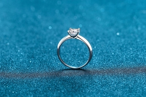 Macro detail of princess cut moissanite set in a polished four-claw silver ring setting