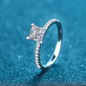 Square princess cut S925 sterling silver ring with pavé diamonds on blue bokeh background