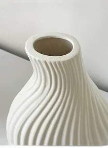 Macro detail of minimalist white ceramic vase with modern 3D wavy texture and matte finish