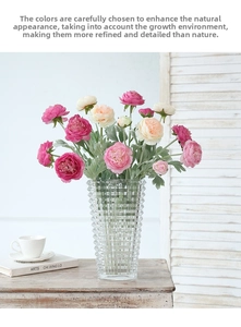 Close-up of artificial Persian buttercup bouquet in a textured glass vase on wooden table