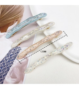 Dettaglio di quattro fermagli per capelli in acetato con glitter lunghi 120 mm