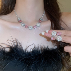 Close-up of sparkling pink zircon flower necklace and earrings set worn by a model