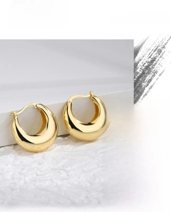 Close-up of gold-plated chunky hoop earrings showing the S925 sterling silver hallmark