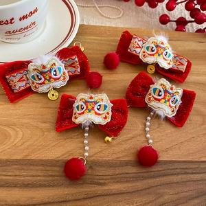 Detail of red velvet bow hair clip with traditional lion dance embroidery and pearl charms
