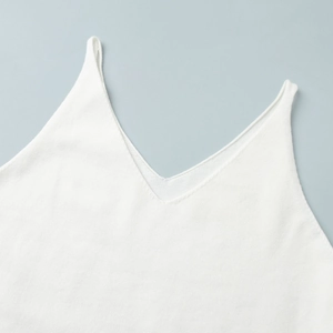 Detail of white knit camisole featuring V-neckline and fine ribbed fabric texture