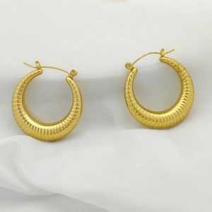Detailed close-up of golden croissant style U-shaped textured hoop earrings for women