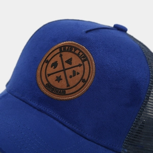 Détail d'une casquette de baseball en daim bleu roi avec filet et écusson en cuir