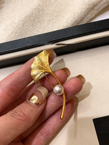 Dettaglio macro della spilla foglia di ginkgo placcata oro 18K con perla bianca