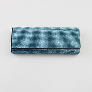 Close-up view of sparkling light blue rhinestone detail on a luxury eyeglass case