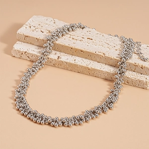 Silver bead cluster necklace with adjustable chain on minimalist travertine background