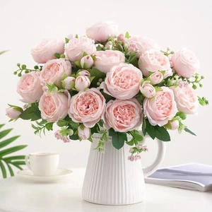 Close-up of pink artificial roses in white ceramic vase for home and wedding decor