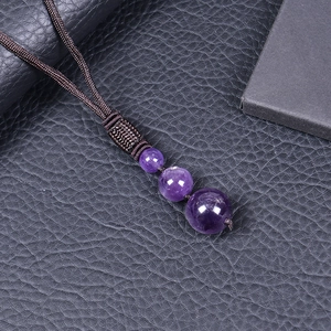 Detailed macro view of triple purple amethyst crystal beads on a woven necklace cord