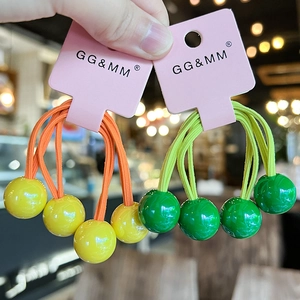Detail of colorful hair ties with glossy plastic spheres on a pink display card