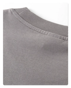 Detalle del cuello redondo acanalado y la textura de punto fino en camiseta gris