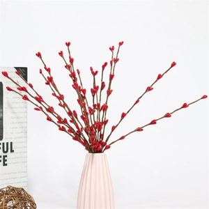 Vibrant red faux berry branches in a ceramic vase for festive holiday decor