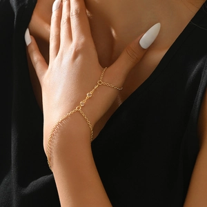 Detail of gold hand chain bracelet with sparkling crystals on model hand with black outfit