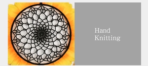 Detailed view of hand-knitted dream catcher with yellow sunflower petals and black mesh
