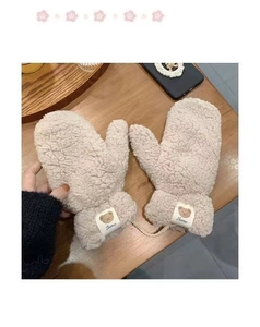 Detail of beige fleece mittens with bear patch and connecting cord on wooden surface