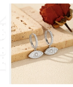Detailed macro of S925 sterling silver evil eye hoop earrings with sparkling zircons