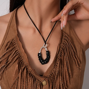 Bohemian sweater necklace detail with silver hollow oval pendant and black woven wrap