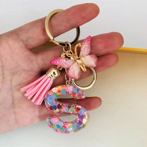 Handheld resin letter S keychain with pink butterfly, tassel, and colorful heart sequins