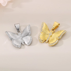 Close-up of gold and silver butterfly pendants with sparkling rhinestones and engravings