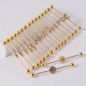 Golden stainless steel industrial barbells with rhinestones, flowers and butterfly designs