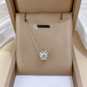 Polished silver cylinder necklace with quilted texture in beige jewelry display box