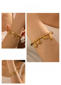 Detail of gold-plated bamboo texture bangle featuring starfish and tropical fish charms