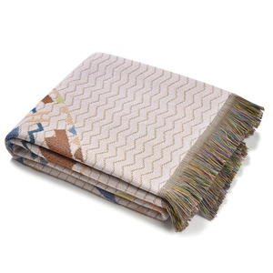 Nahaufnahme der Boho-Strickdecke mit bunten Wellenmustern und Fransenverzierung