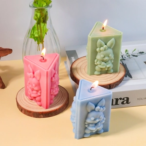 Detailed relief bunny candles in pink, green, and blue on rustic wood coasters