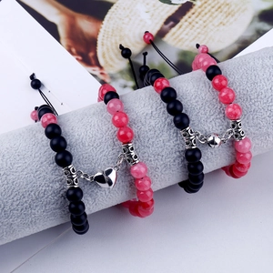 Close-up of black and pink natural stone beaded bracelets with heart magnetic clasps
