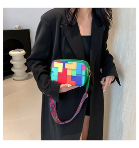 Detail of colorful geometric block pattern crossbody bag with textured wide strap