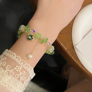 Süßes grünes Kristall-Planetenarmband mit Goldakzenten am Handgelenk in eleganter Szene