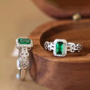 Dettaglio macro di anelli con pietre verdi taglio smeraldo e montatura in argento