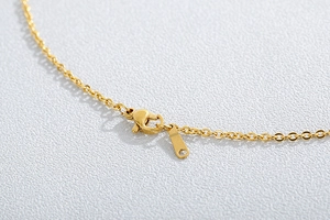 Macro shot of gold stainless steel necklace chain with a secure lobster clasp detail