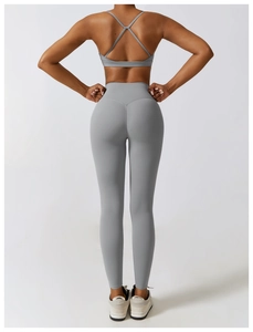 Détail d'un ensemble de yoga gris avec brassière à dos croisé et legging taille haute