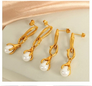 Detail of 18K gold chain earrings with drop pearls on a minimalist silk background
