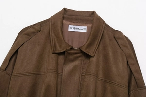 Détail du col d'un blouson aviateur en daim marron avec coutures et étiquette de marque