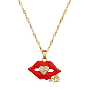 Gold lip necklace with red enamel, heart zircon, and a Kiss charm on white background