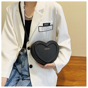 Détail du sac à bandoulière en forme de cœur en cuir PU noir avec lettres dorées