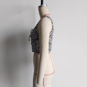 Detail van crop top met dierenprint, zijaanzicht op mannequin en vetersluiting op de borst