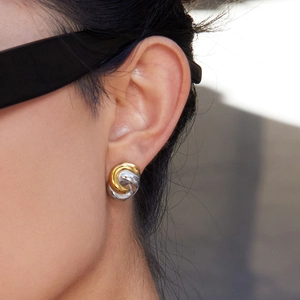 Klassische zweifarbige gedrehte Knotenohrringe aus 18K Gold und Silber am Model getragen