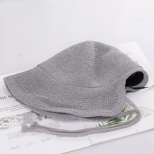 Detail of grey woven bucket hat with adjustable chin strap and textured knit finish