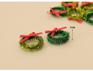 Detail view of 1cm miniature Christmas wreaths with tiny red bows for DIY craft scenes