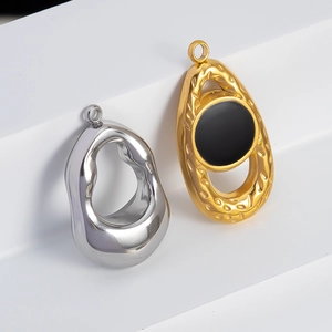 Détail de pendentifs gouttes argentés et martelés dorés avec centre noir élégant