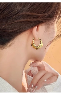 Close-up of model wearing 18K gold plated V-shape lava textured hoop earrings for women