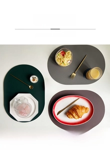 Detail showing oval faux leather placemats with lychee texture in deep green and grey